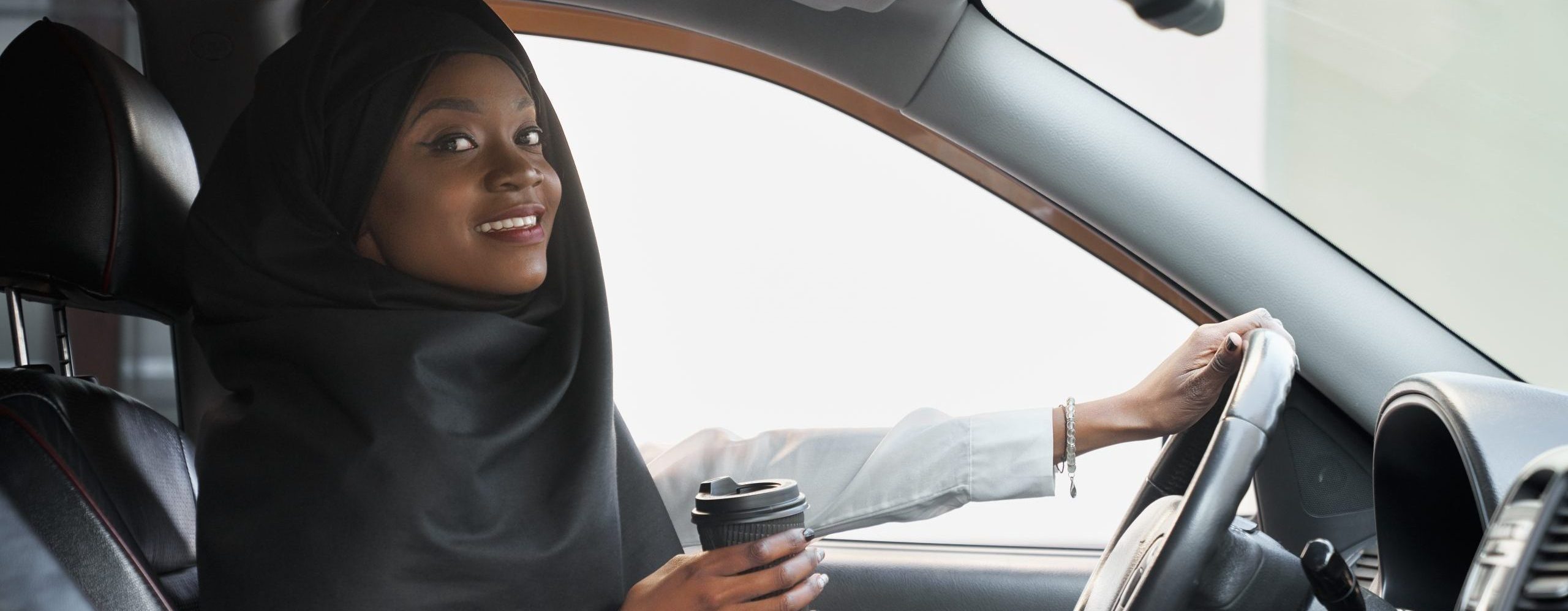 Cheerful african woman posing, holding coffee cup.