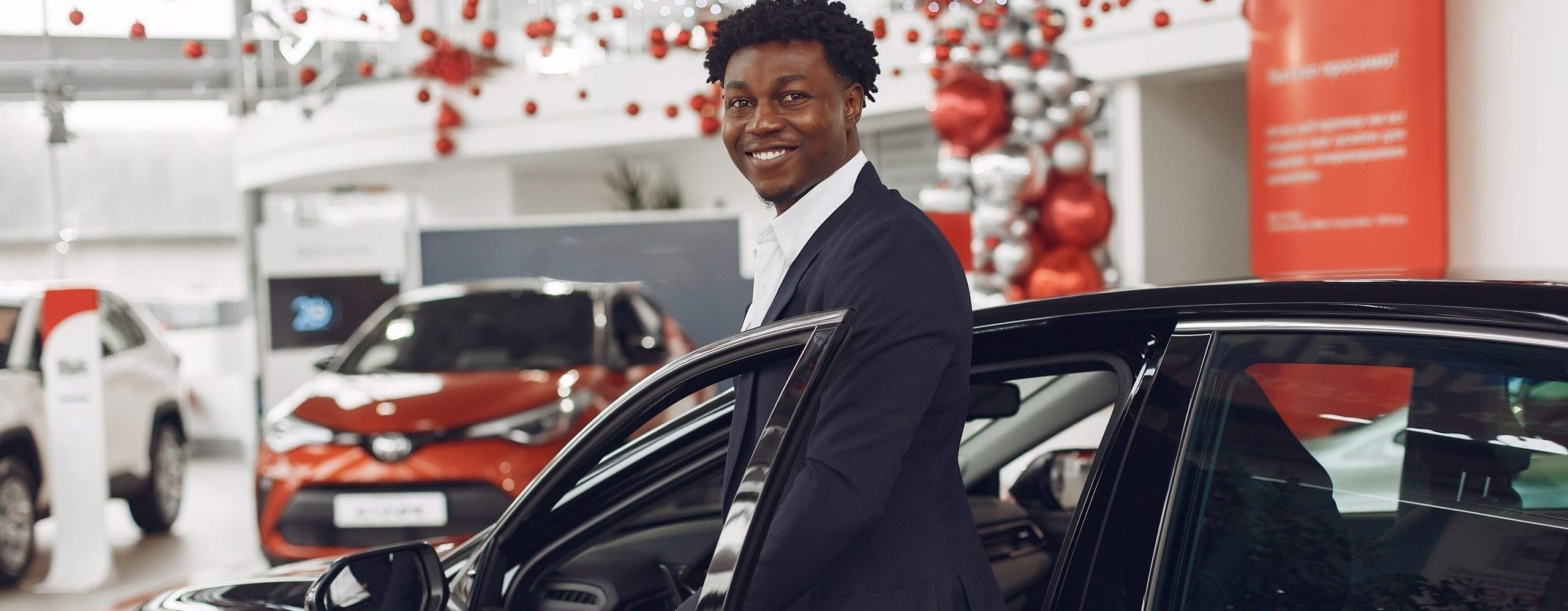 Handsome and elegant black man in a car salon